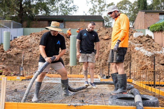 a bunch of workers working together on slab foundation