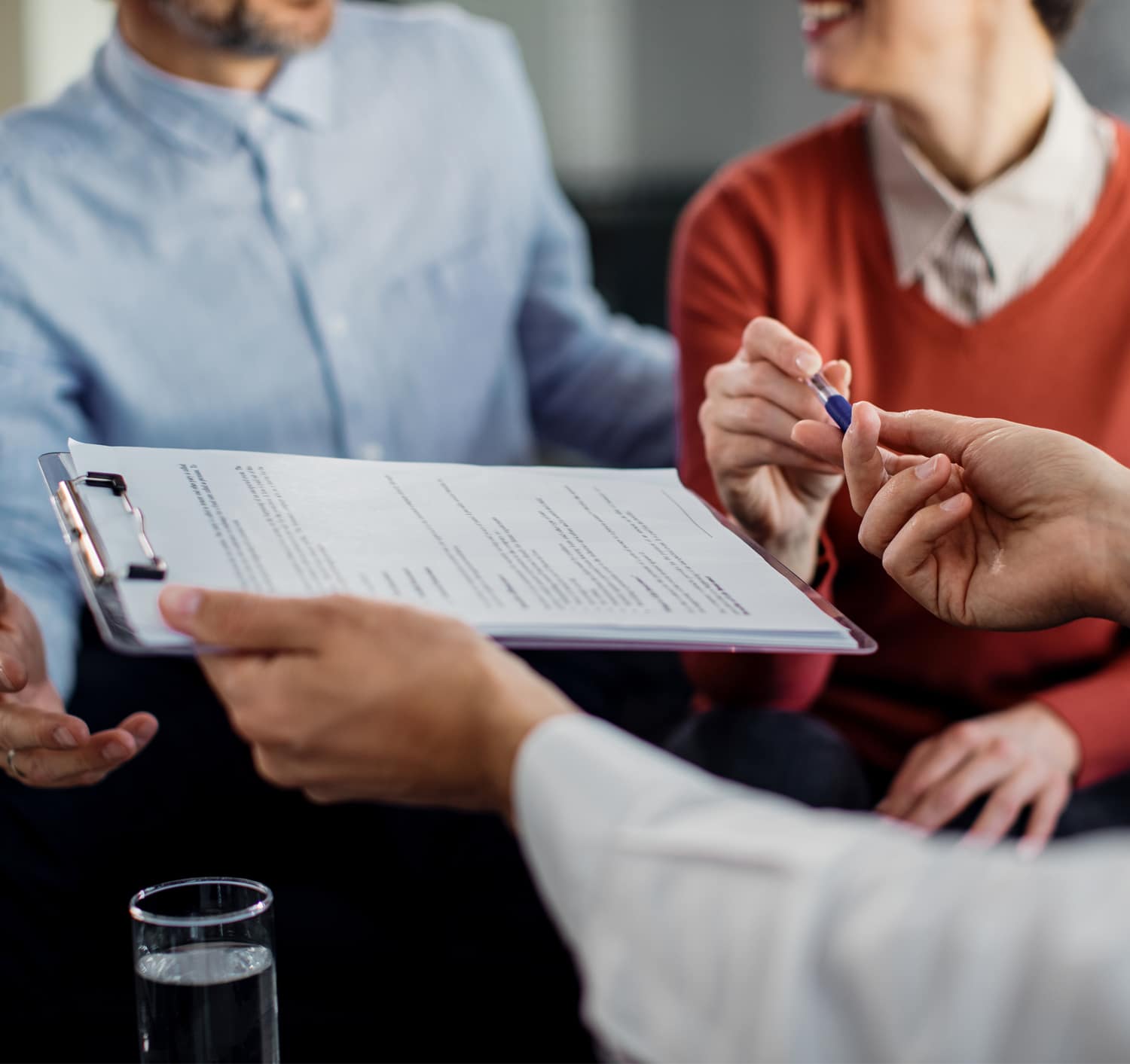 closeup of people signing a document